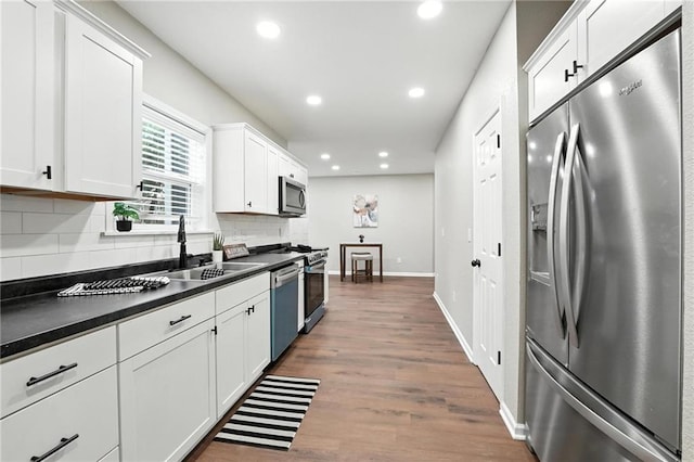 602 N College St, Richmond, MO 64085 - kitchen with appliances with stainless steel finishes, dark countertops, recessed lighting, tasteful backsplash, and white cabinets