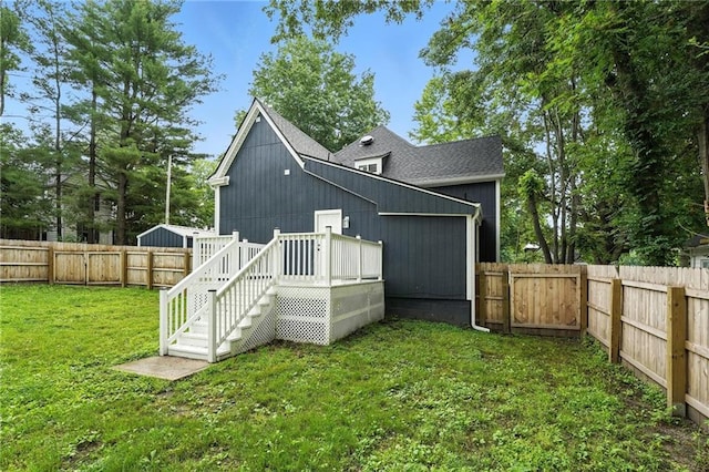 602 N College St, Richmond, MO 64085 - back of house featuring a fenced backyard, a shingled roof, and a deck