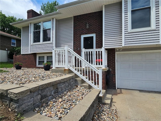 4513 Alpha Ln, Saint Joseph, MO 64506 - entrance to property featuring brick siding, an attached garage, and a chimney