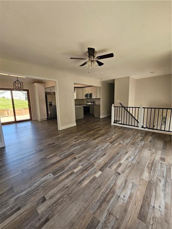 4513 Alpha Ln, Saint Joseph, MO 64506 - unfurnished living room with dark wood finished floors, a ceiling fan, and baseboards
