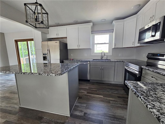 4513 Alpha Ln, Saint Joseph, MO 64506 - kitchen featuring stainless steel appliances, a sink, dark stone countertops, and plenty of natural light