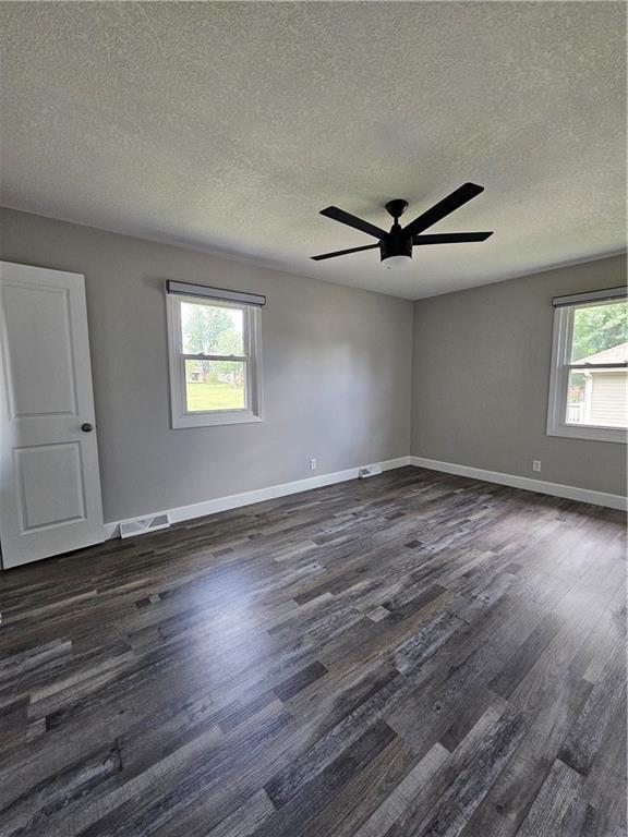 4513 Alpha Ln, Saint Joseph, MO 64506 - empty room featuring a textured ceiling, dark wood-style floors, ceiling fan, and baseboards