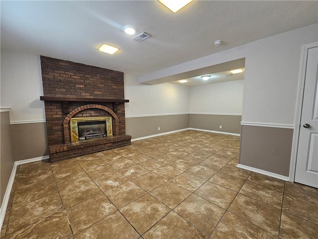 4513 Alpha Ln, Saint Joseph, MO 64506 - unfurnished living room featuring tile patterned flooring, baseboards, a textured ceiling, and a fireplace