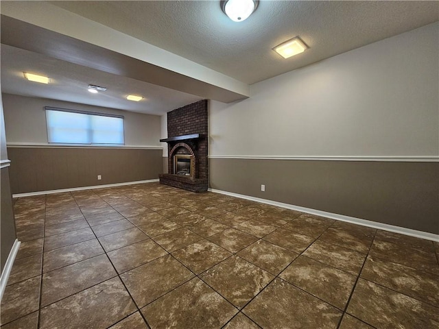 4513 Alpha Ln, Saint Joseph, MO 64506 - basement with a textured ceiling, a brick fireplace, tile patterned floors, and baseboards