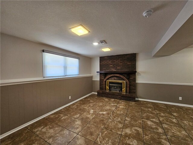 4513 Alpha Ln, Saint Joseph, MO 64506 - unfurnished living room featuring a fireplace, a textured ceiling, wainscoting, tile patterned flooring, and baseboards