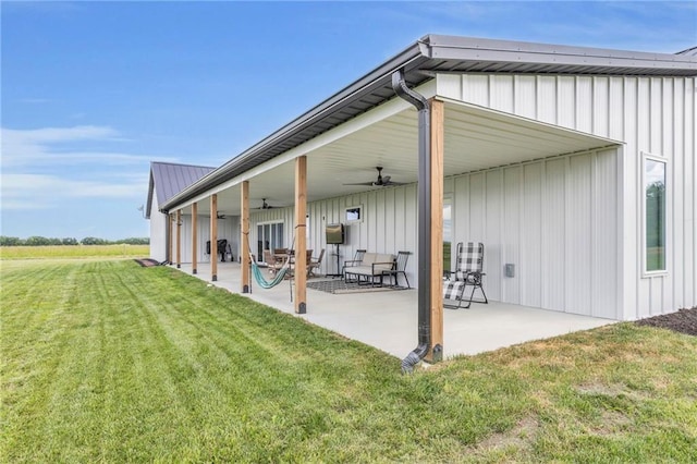 2363 Bainbridge Rd, Bates City, MO 64011 - back of property with ceiling fan, a yard, a patio area, metal roof, and board and batten siding