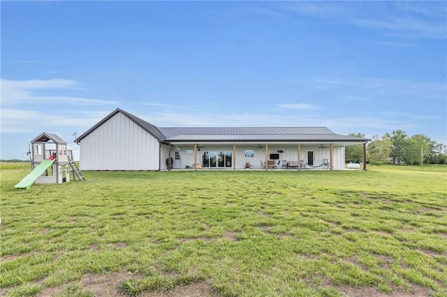 2363 Bainbridge Rd, Bates City, MO 64011 - back of house with board and batten siding, a yard, a playground, and a patio