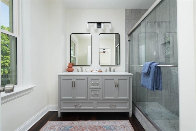 1795 S Norwood Ave, Independence, MO 64052 - full bathroom featuring wood finished floors, double vanity, a stall shower, and baseboards