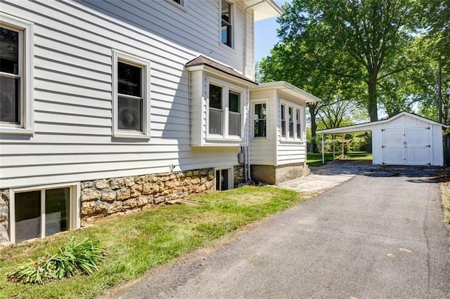 1795 S Norwood Ave, Independence, MO 64052 - view of property exterior with a detached carport, driveway, and an outdoor structure