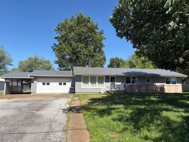 22025 Ness Rd, Parsons, KS 67357 - ranch-style house with an attached garage, a front yard, and driveway