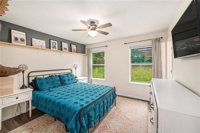 5862 SW Reed Ln, Trimble, MO 64492 - bedroom featuring a textured ceiling, light wood-style floors, ceiling fan, and baseboards