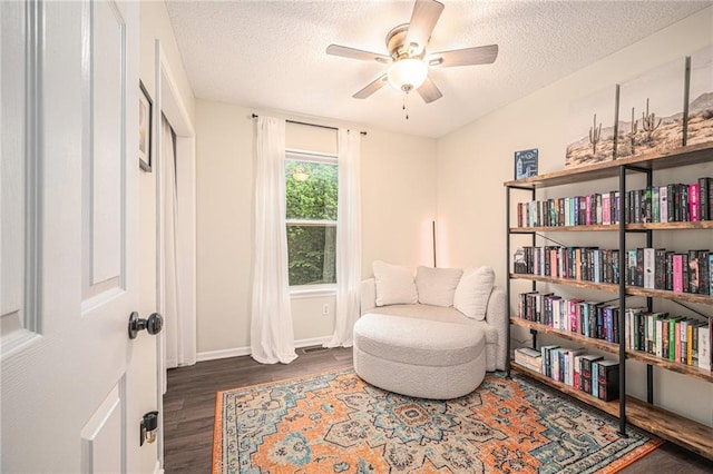 5862 SW Reed Ln, Trimble, MO 64492 - living area featuring wood finished floors, a textured ceiling, a ceiling fan, and baseboards