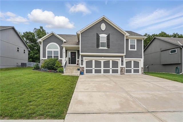 1106 E 14th St, Kearney, MO 64060 - split level home featuring an attached garage, a front yard, concrete driveway, stone siding, and central AC