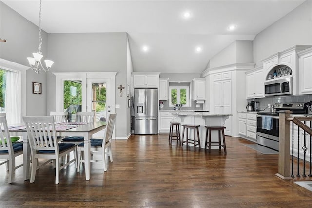 1106 E 14th St, Kearney, MO 64060 - dining area featuring a chandelier, plenty of natural light, dark wood-style flooring, high vaulted ceiling, and recessed lighting