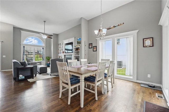 1106 E 14th St, Kearney, MO 64060 - dining area featuring a towering ceiling, a fireplace, a ceiling fan, dark wood-type flooring, and a chandelier