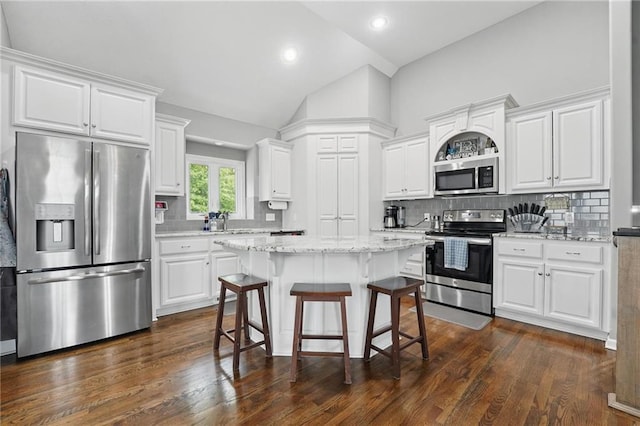 1106 E 14th St, Kearney, MO 64060 - kitchen with appliances with stainless steel finishes, vaulted ceiling, a breakfast bar area, white cabinetry, and recessed lighting