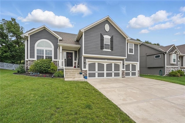 1106 E 14th St, Kearney, MO 64060 - tri-level home featuring a garage, stone siding, and concrete driveway