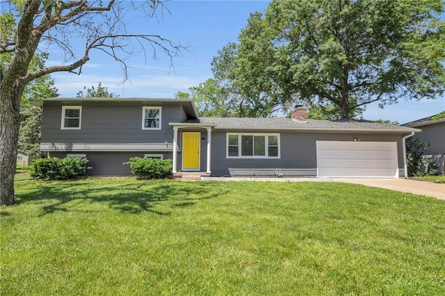 1018 S Elm St, Ottawa, KS 66067 - tri-level home featuring a chimney, a garage, driveway, and a front lawn