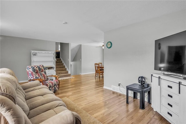 1018 S Elm St, Ottawa, KS 66067 - living room with stairs, light wood-style floors, baseboards, and a ceiling fan