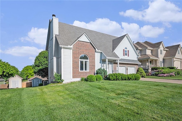 3304 Tepee Ct, Independence, MO 64057 - view of front of property with brick siding, a chimney, a front yard, driveway, and an attached garage