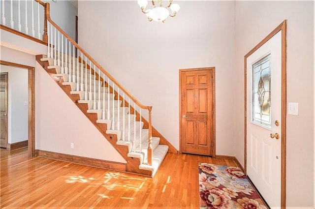 3304 Tepee Ct, Independence, MO 64057 - entryway featuring stairway, wood finished floors, baseboards, a towering ceiling, and a chandelier
