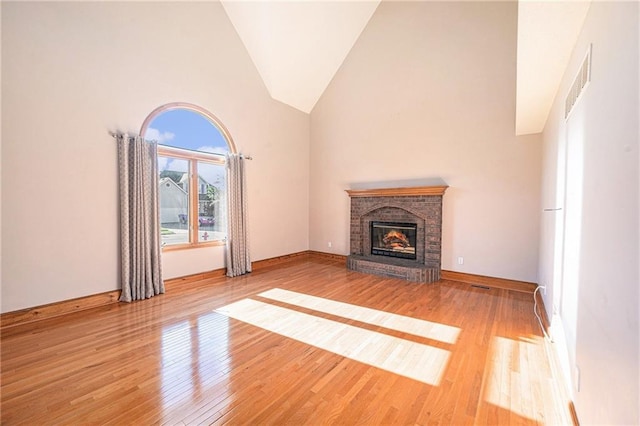 3304 Tepee Ct, Independence, MO 64057 - unfurnished living room featuring high vaulted ceiling, a fireplace, wood finished floors, and baseboards