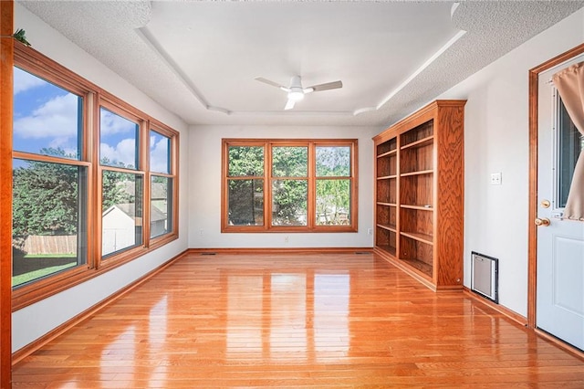 3304 Tepee Ct, Independence, MO 64057 - unfurnished room featuring a tray ceiling, light wood-type flooring, a ceiling fan, baseboards, and built in shelves