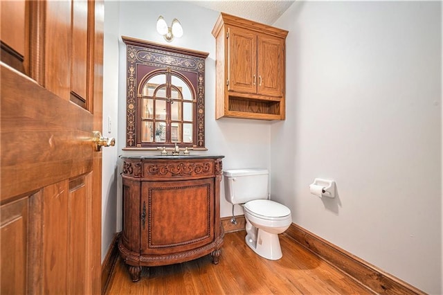 3304 Tepee Ct, Independence, MO 64057 - half bath with toilet, wood finished floors, baseboards, and vanity