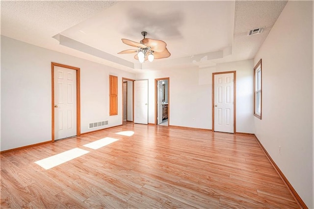 3304 Tepee Ct, Independence, MO 64057 - unfurnished bedroom with a tray ceiling, light wood-type flooring, baseboards, and ensuite bathroom