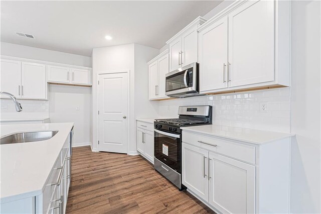 5000 NW 141st St, Platte City, MO 64079 - kitchen with stainless steel appliances, a sink, recessed lighting, wood finished floors, and decorative backsplash