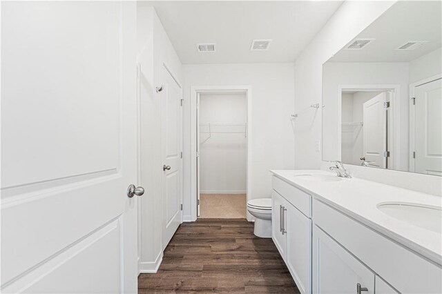 5000 NW 141st St, Platte City, MO 64079 - bathroom featuring double vanity, wood finished floors, a walk in closet, and toilet
