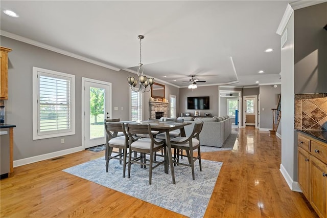 1602 SW Deer Run Rd, Oak Grove, MO 64075 - dining space with a fireplace, baseboards, light wood-style floors, crown molding, and ceiling fan