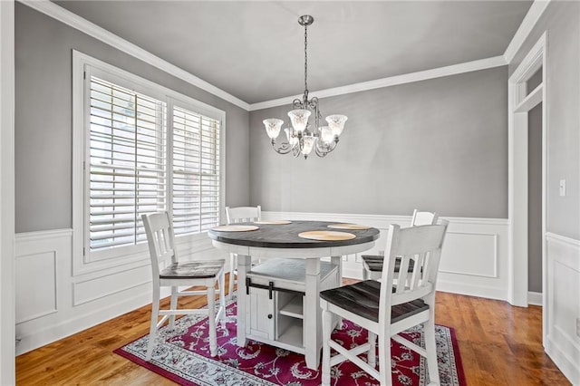 1602 SW Deer Run Rd, Oak Grove, MO 64075 - dining space featuring wainscoting, ornamental molding, wood finished floors, a chandelier, and a decorative wall
