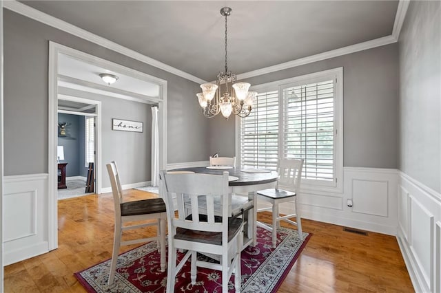 1602 SW Deer Run Rd, Oak Grove, MO 64075 - dining room featuring a wainscoted wall, a chandelier, wood finished floors, and crown molding