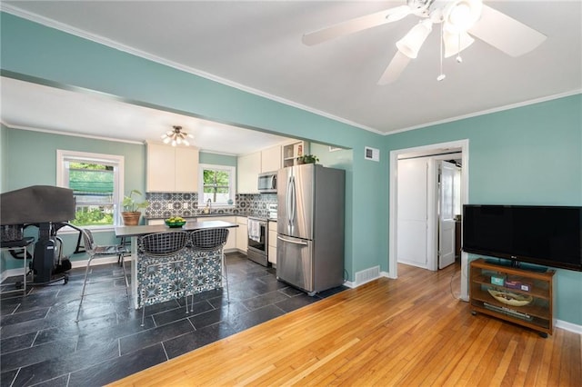 11410 W 68th Ter, Shawnee, KS 66203 - kitchen with stainless steel appliances, white cabinetry, crown molding, tasteful backsplash, and baseboards