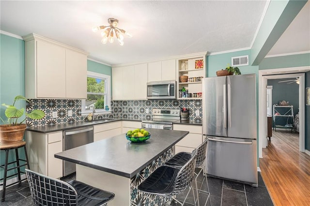 11410 W 68th Ter, Shawnee, KS 66203 - kitchen featuring stainless steel appliances, dark countertops, a sink, open shelves, and a breakfast bar