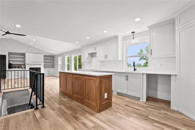 308 N 22nd St, Leavenworth, KS 66048 - kitchen featuring a kitchen island, decorative backsplash, recessed lighting, light wood-style flooring, and vaulted ceiling