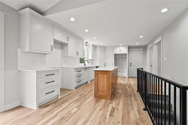 308 N 22nd St, Leavenworth, KS 66048 - kitchen with light wood-style floors, a center island, recessed lighting, backsplash, and white cabinetry