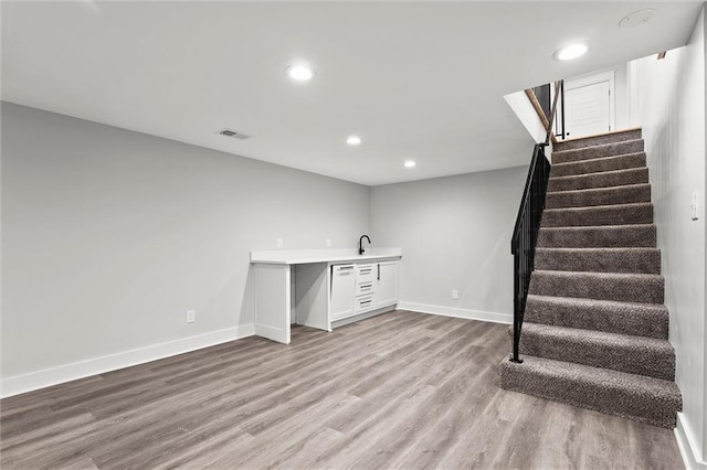 308 N 22nd St, Leavenworth, KS 66048 - finished basement with stairway, wood finished floors, bar with sink, recessed lighting, and baseboards