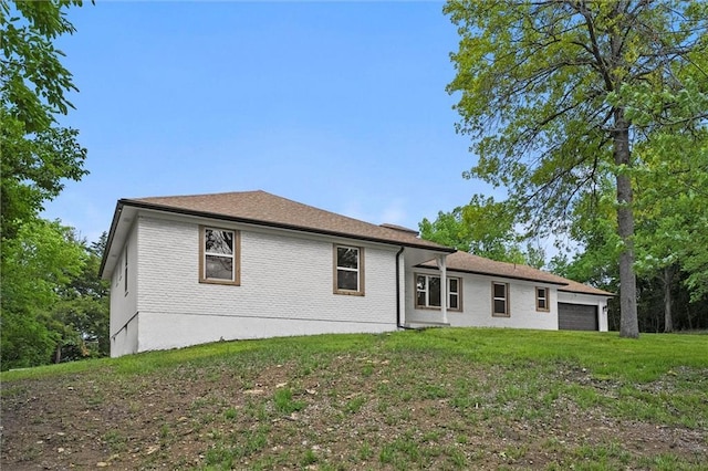 308 N 22nd St, Leavenworth, KS 66048 - back of house with a lawn, a garage, and brick siding