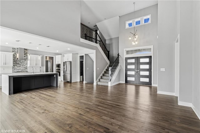 10429 W 170th Pl, Overland Park, KS 66221 - foyer entrance with a towering ceiling, stairs, french doors, dark wood-style floors, and a chandelier