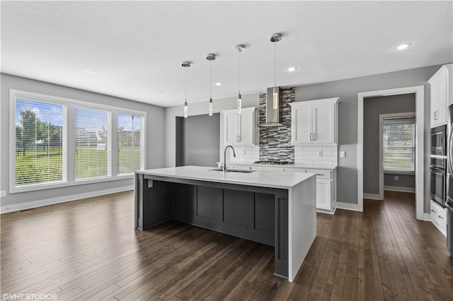 10429 W 170th Pl, Overland Park, KS 66221 - kitchen with wall chimney exhaust hood, tasteful backsplash, light countertops, dark wood-style floors, and white cabinetry