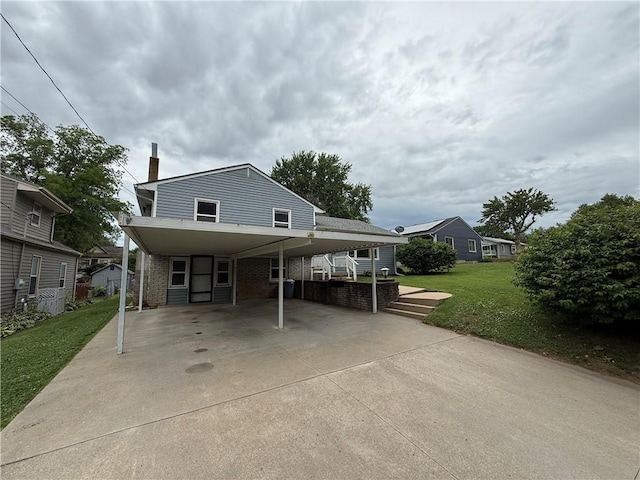 316 N 18th St, Lexington, MO 64067 - view of front facade with concrete driveway, a front yard, brick siding, a chimney, and a carport