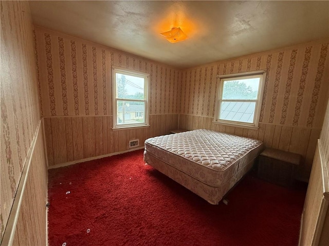 316 N 18th St, Lexington, MO 64067 - bedroom with multiple windows, wallpapered walls, a wainscoted wall, carpet floors, and wooden walls