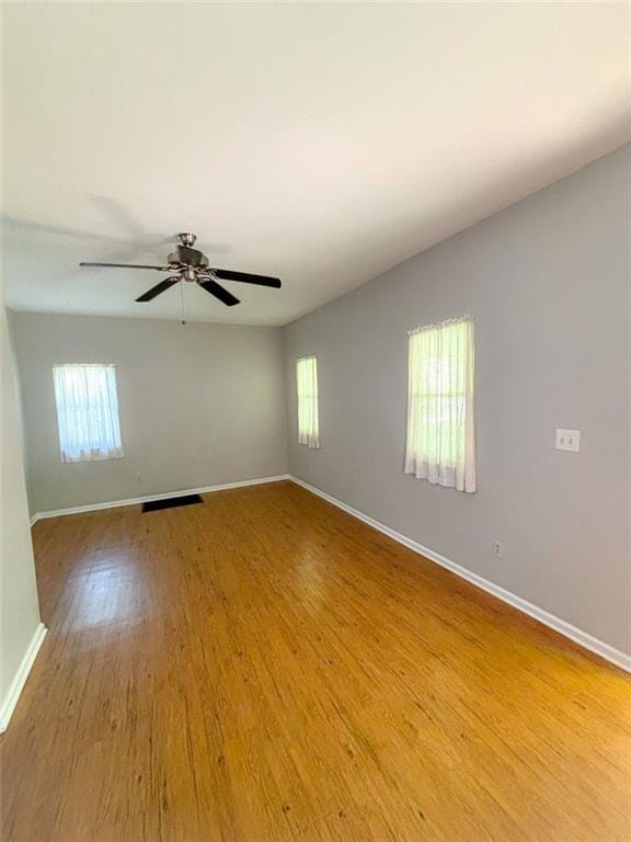 8106 Oak St, Kansas City, MO 64114 - empty room with plenty of natural light, wood finished floors, and baseboards