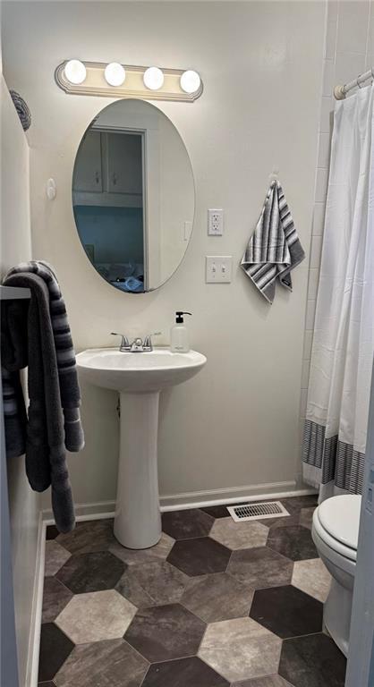 8106 Oak St, Kansas City, MO 64114 - bathroom with toilet and baseboards