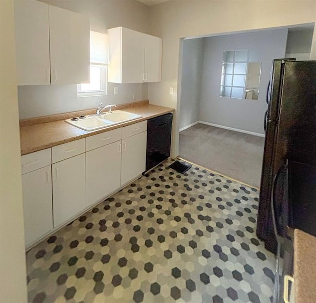 8106 Oak St, Kansas City, MO 64114 - kitchen with a sink, black dishwasher, white cabinets, light countertops, and carpet floors