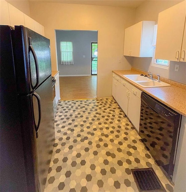 8106 Oak St, Kansas City, MO 64114 - kitchen featuring black appliances, a sink, light countertops, and white cabinetry