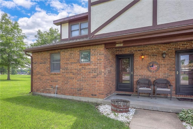 1101 Jeff Cir, Paola, KS 66071 - doorway to property featuring brick siding, a yard, and stucco siding
