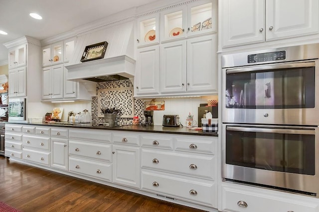 10309 S Oakcrest Ln, Olathe, KS 66061 - kitchen featuring stainless steel double oven, dark countertops, white cabinets, glass insert cabinets, and recessed lighting